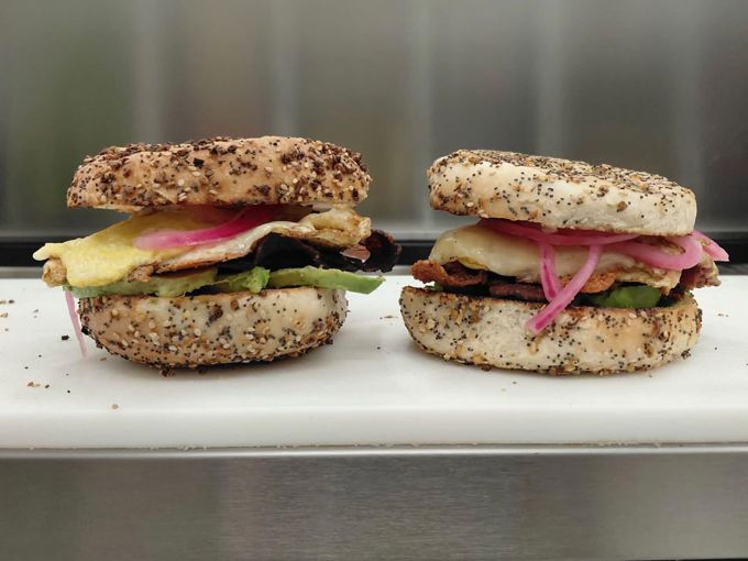 Two breakfast sandwiches on everything bagels