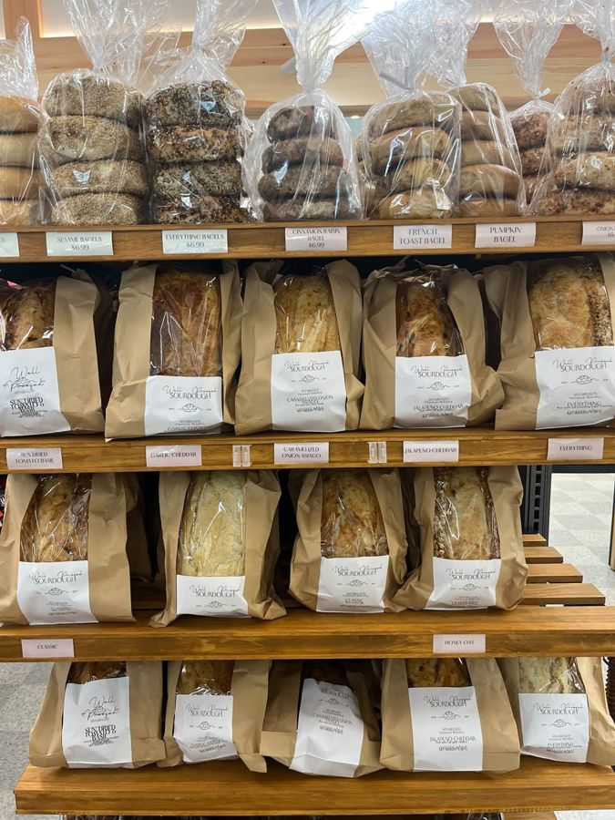 Well Proofed sourdough loaves below a shelf of bagels