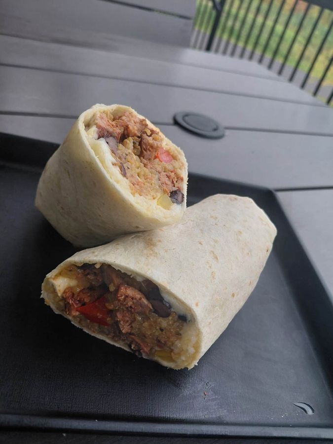 A breakfast burrito cut in half on a tray