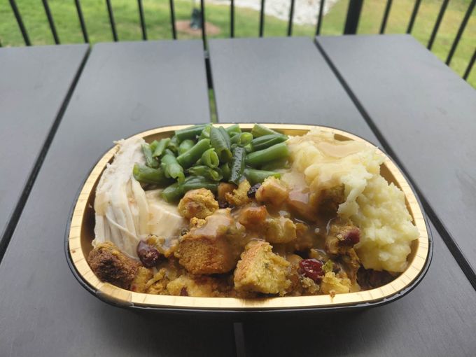 A prepared meal with turkey, mashed potatoes, vegetables and stuffing