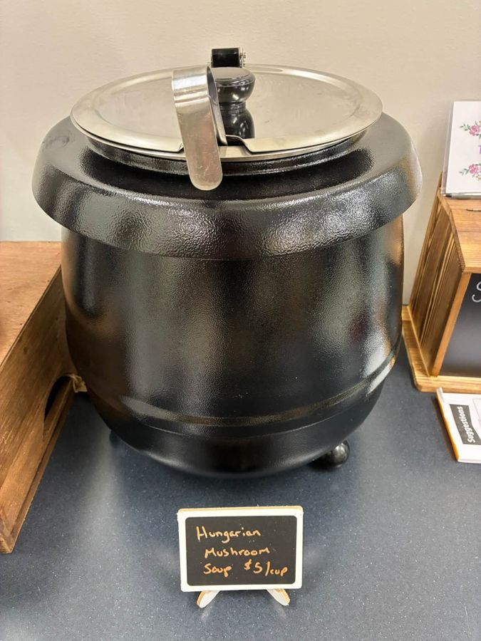 A soup kettle with a handwritten Hungarian mushroom soup sign