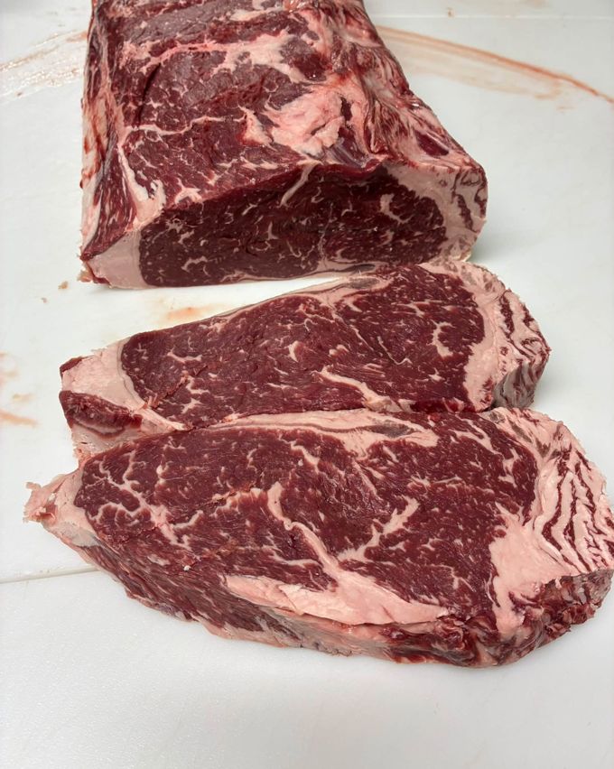 Marbled beef cut into steaks on a butcher board