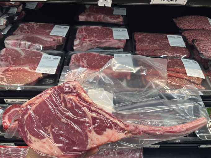 A long-bone steak in a vacuum pouch at the butcher case
